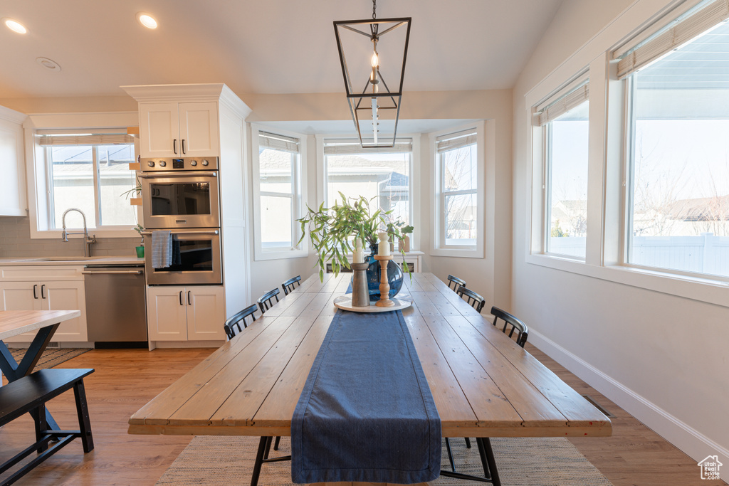 Dining room featuring baseboards, recessed lighting, a chandelier, and light wood-style floors