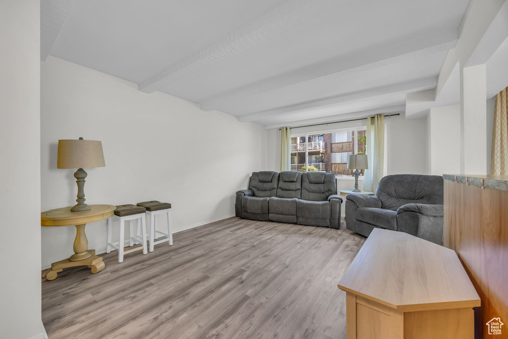 Living room featuring wood finished floors and beamed ceiling