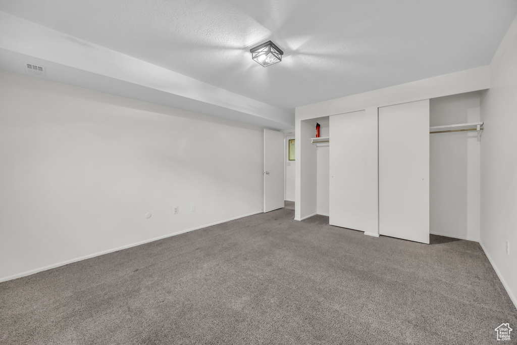 Unfurnished bedroom featuring two closets, carpet floors, baseboards, and visible vents