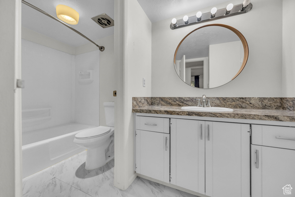 Full bath featuring toilet, tub / shower combination, marble finish floor, and vanity