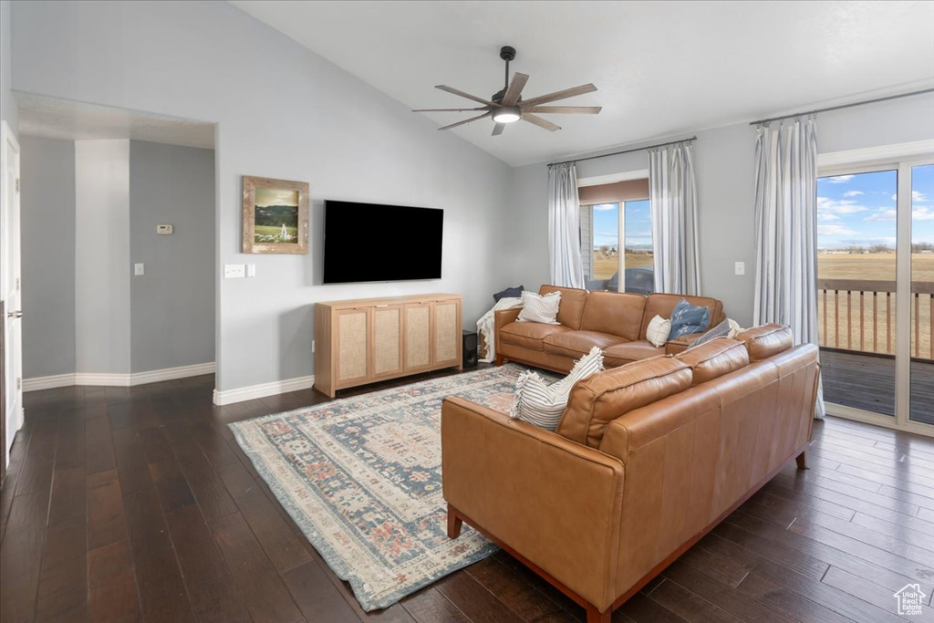 Living area featuring lofted ceiling, a ceiling fan, and dark wood-type flooring