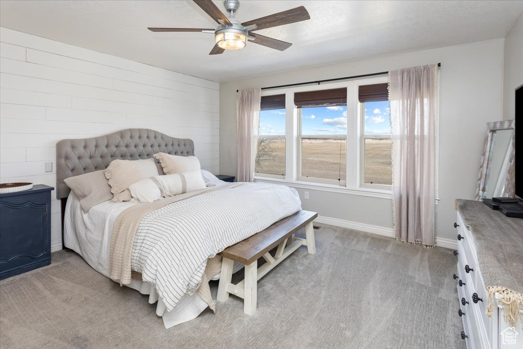 Bedroom with ceiling fan, baseboards, and light colored carpet