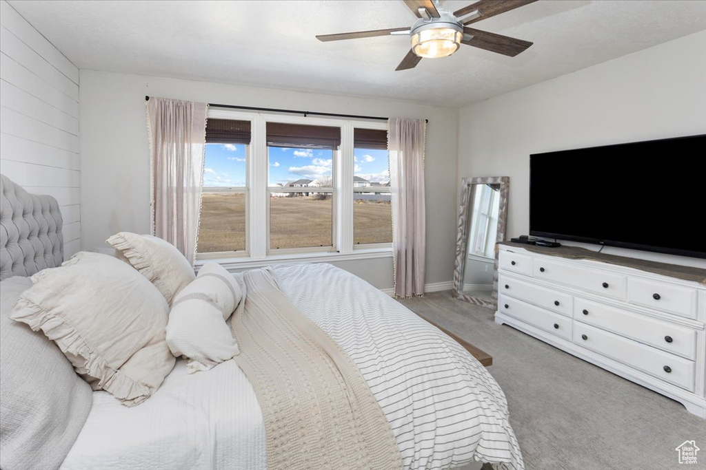 Bedroom featuring ceiling fan, baseboards, and light colored carpet