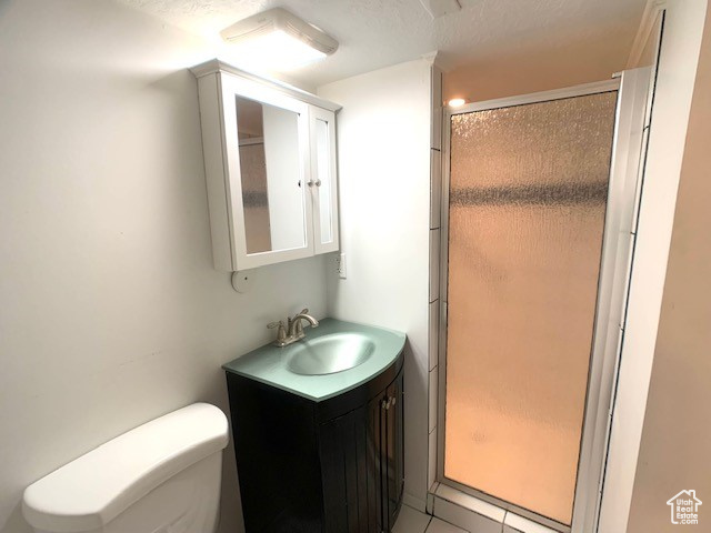 Bathroom with vanity, a stall shower, and toilet
