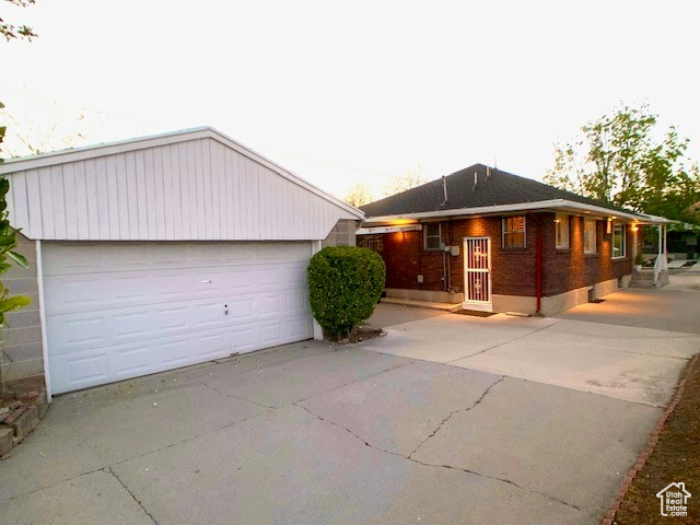 View of front of property with a detached garage and brick siding