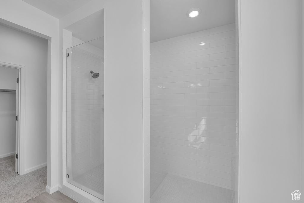 Bathroom featuring a stall shower, baseboards, a spacious closet, and recessed lighting
