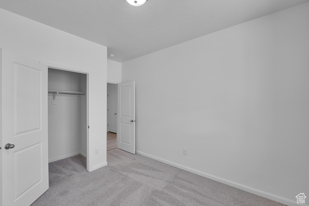 Unfurnished bedroom with a closet, baseboards, and carpet