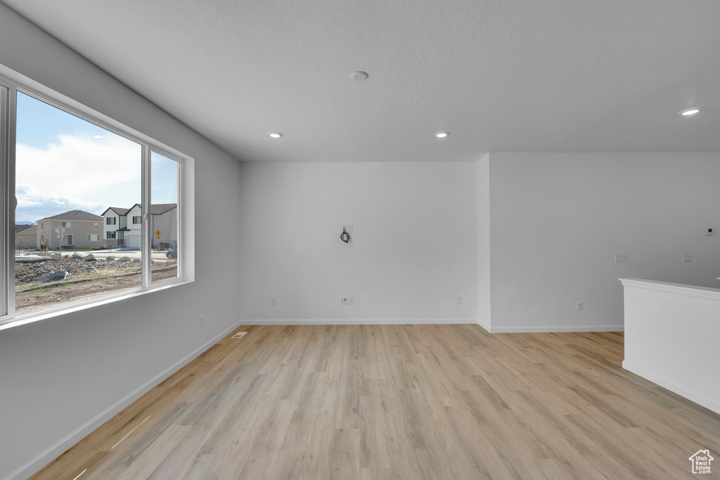 Unfurnished room featuring light wood-type flooring, baseboards, and recessed lighting