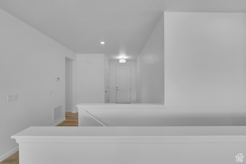 Interior space with visible vents, baseboards, and wood finished floors