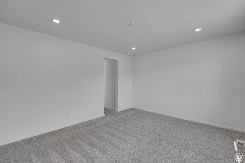 Carpeted spare room with baseboards and recessed lighting