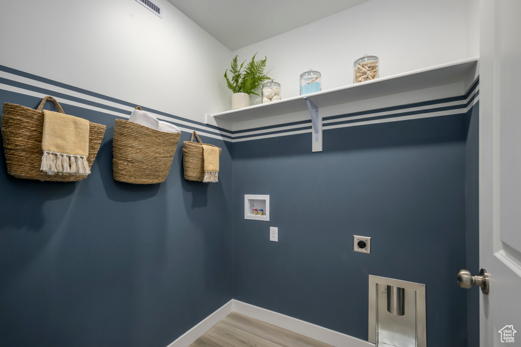 Laundry area with hookup for a washing machine, light wood-style flooring, laundry area, baseboards, and electric dryer hookup