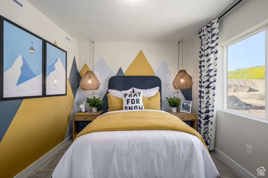 Carpeted bedroom with a textured ceiling, visible vents, and baseboards
