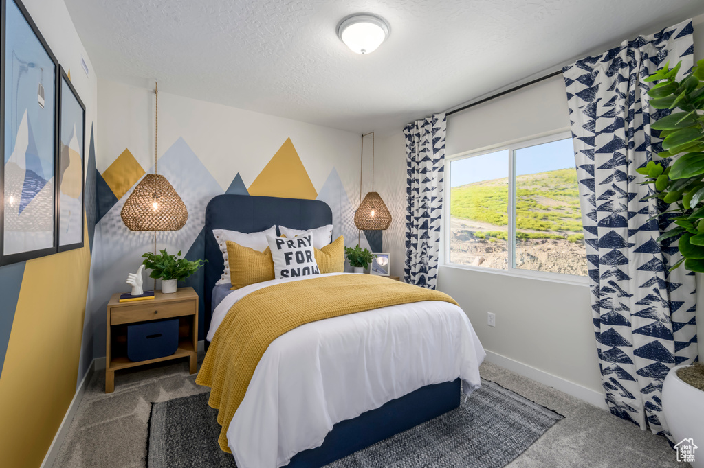 Bedroom with a textured ceiling, carpet flooring, and baseboards