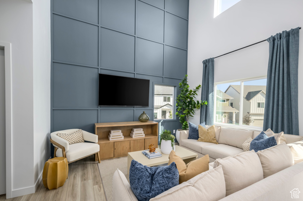 Living room featuring a towering ceiling and wood finished floors