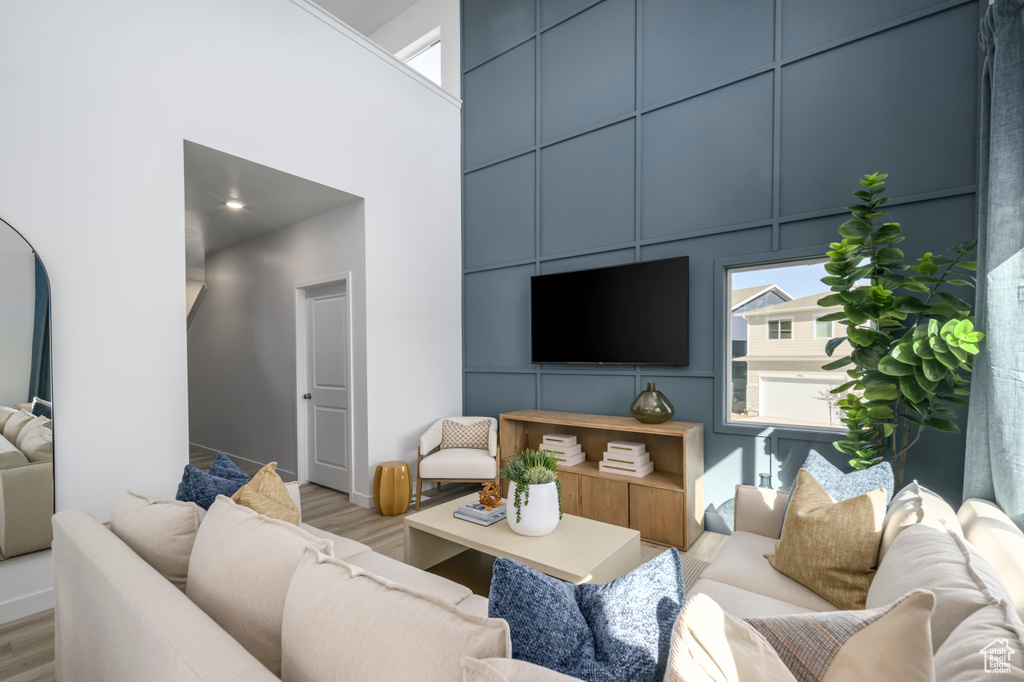 Living area with light wood finished floors and a high ceiling