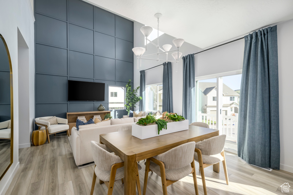 Dining room featuring light wood-type flooring, plenty of natural light, and a chandelier