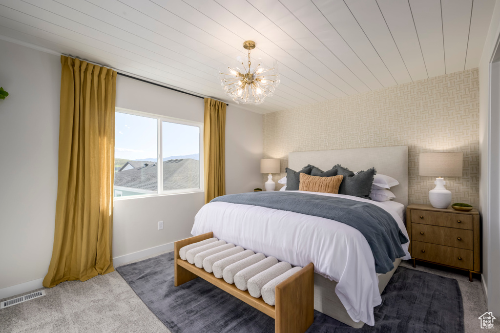 Bedroom with baseboards, visible vents, wood ceiling, an inviting chandelier, and carpet floors