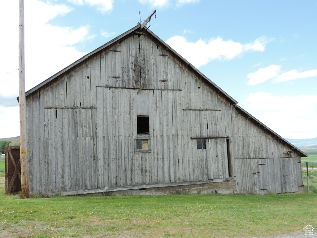 View of barn featuring a lawn