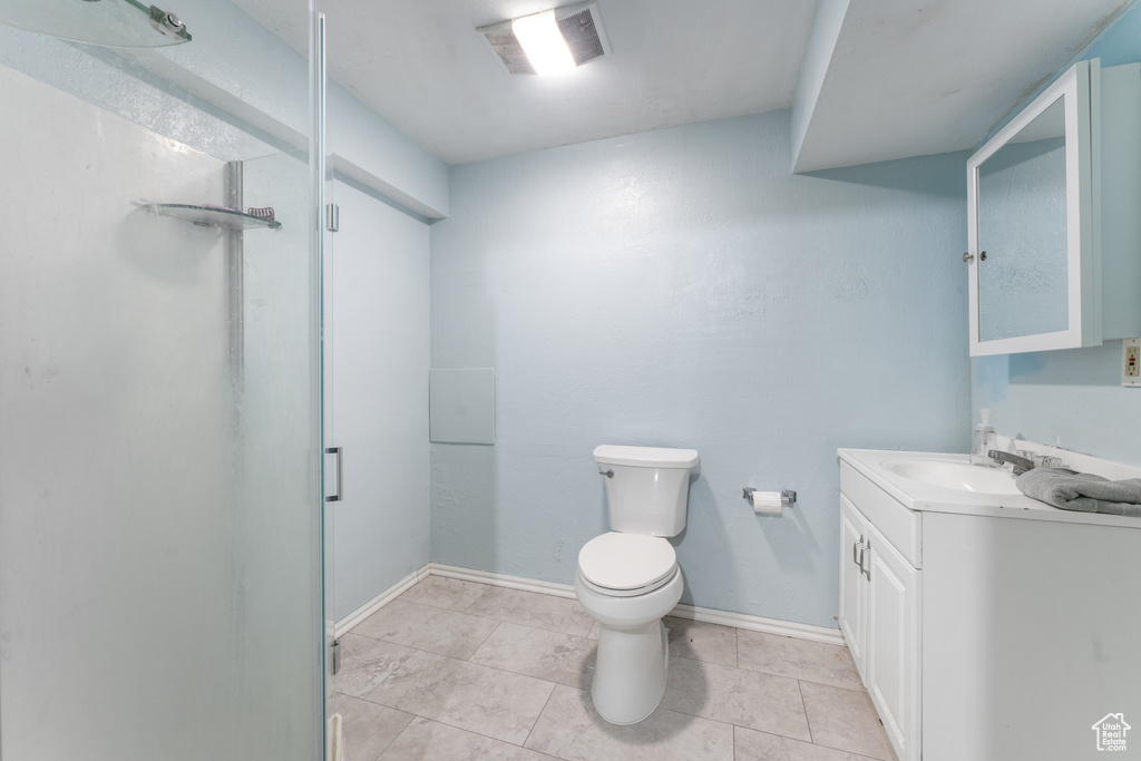 Bathroom featuring a stall shower, visible vents, vanity, and toilet