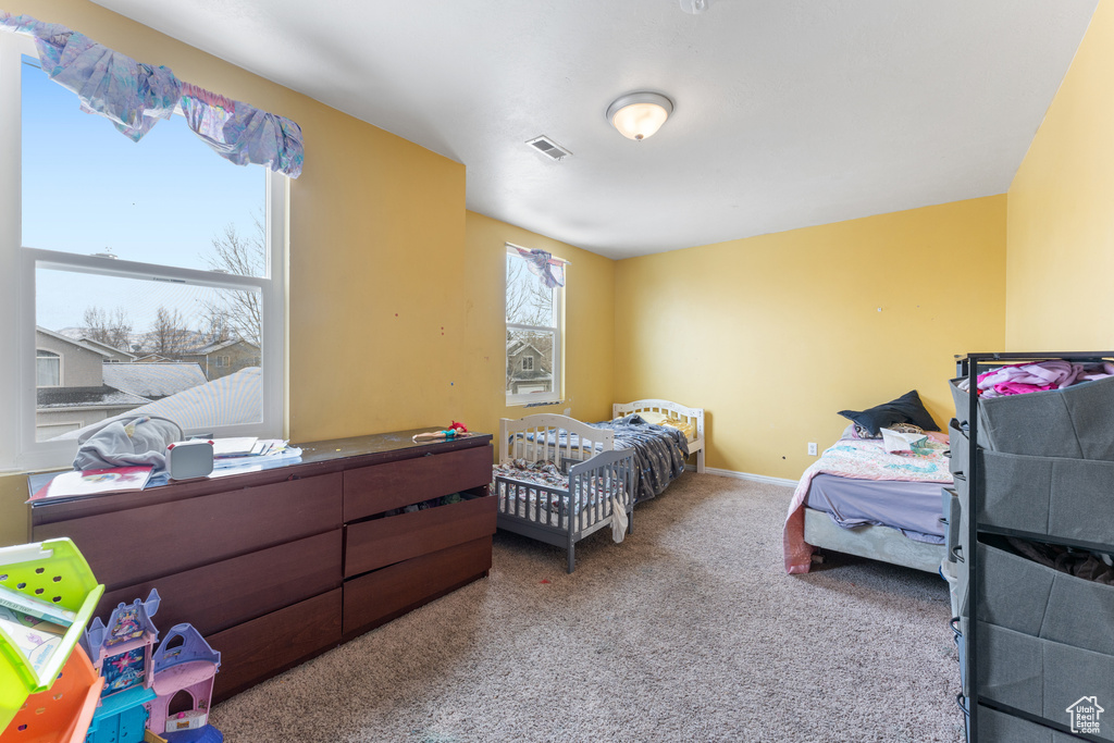 Bedroom featuring carpet floors, visible vents, and baseboards