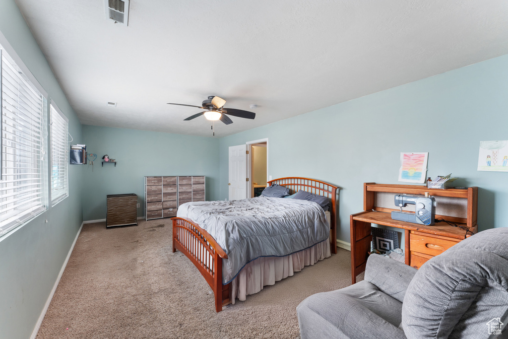 Bedroom with baseboards, visible vents, ceiling fan, and light colored carpet