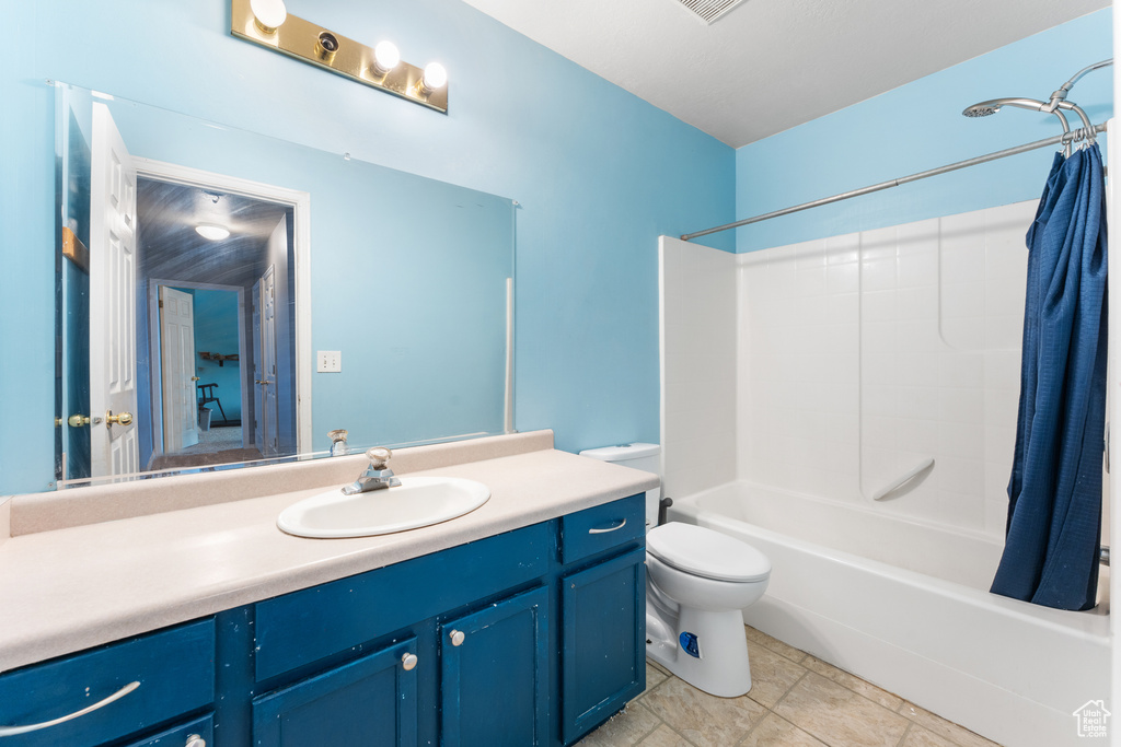 Bathroom featuring shower / tub combo with curtain, vanity, and toilet