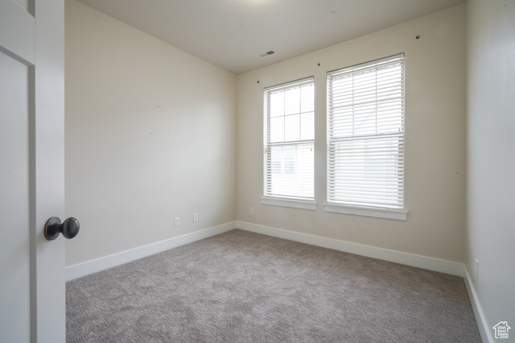 Carpeted empty room with baseboards