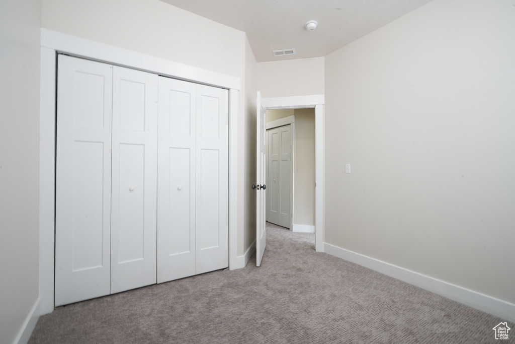 Unfurnished bedroom featuring carpet flooring and a closet