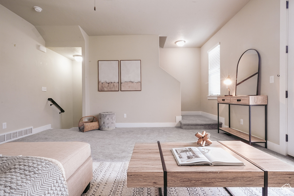 Living area featuring carpet flooring and baseboards
