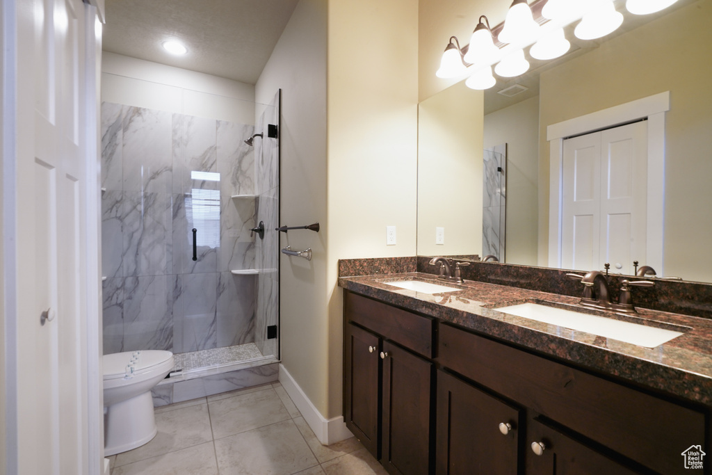Full bathroom with a marble finish shower and double vanity