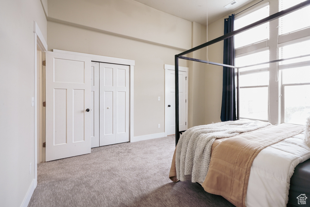 Carpeted bedroom with multiple closets and baseboards