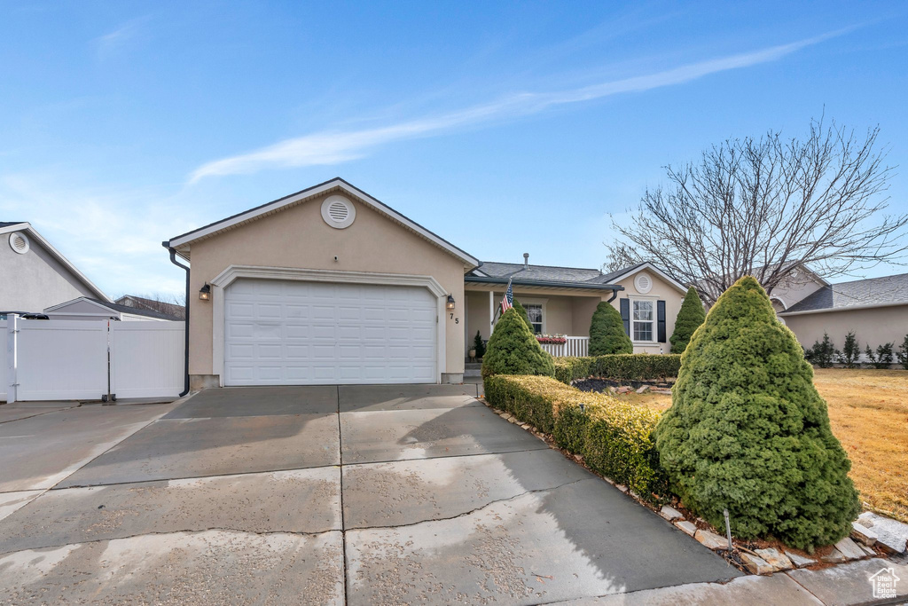 Single story home featuring concrete driveway, fence, an attached garage, and stucco siding