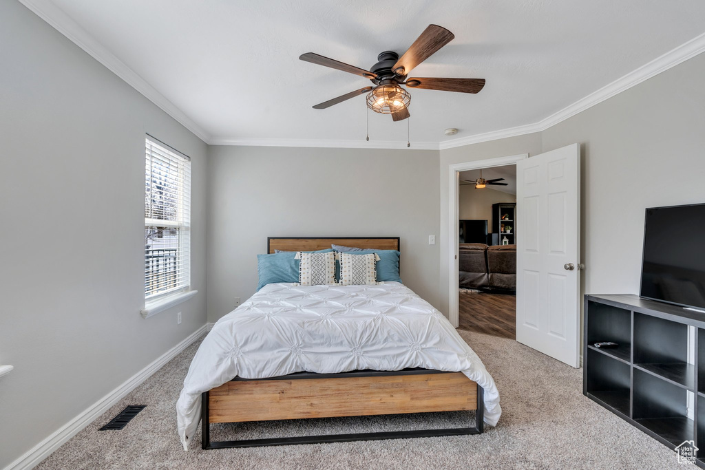 Bedroom with ornamental molding, carpet flooring, visible vents, and baseboards