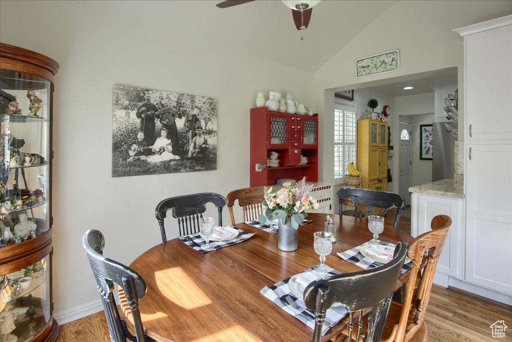 Dining space featuring light wood-type flooring, ceiling fan, and vaulted ceiling