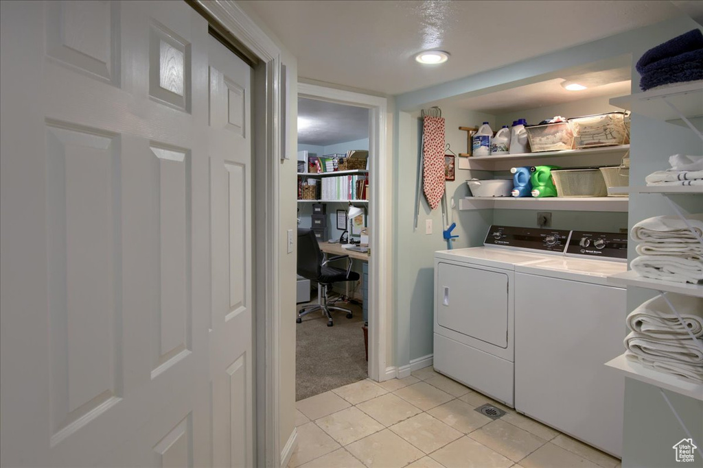 Laundry room featuring laundry area, washing machine and clothes dryer, and light tile patterned floors