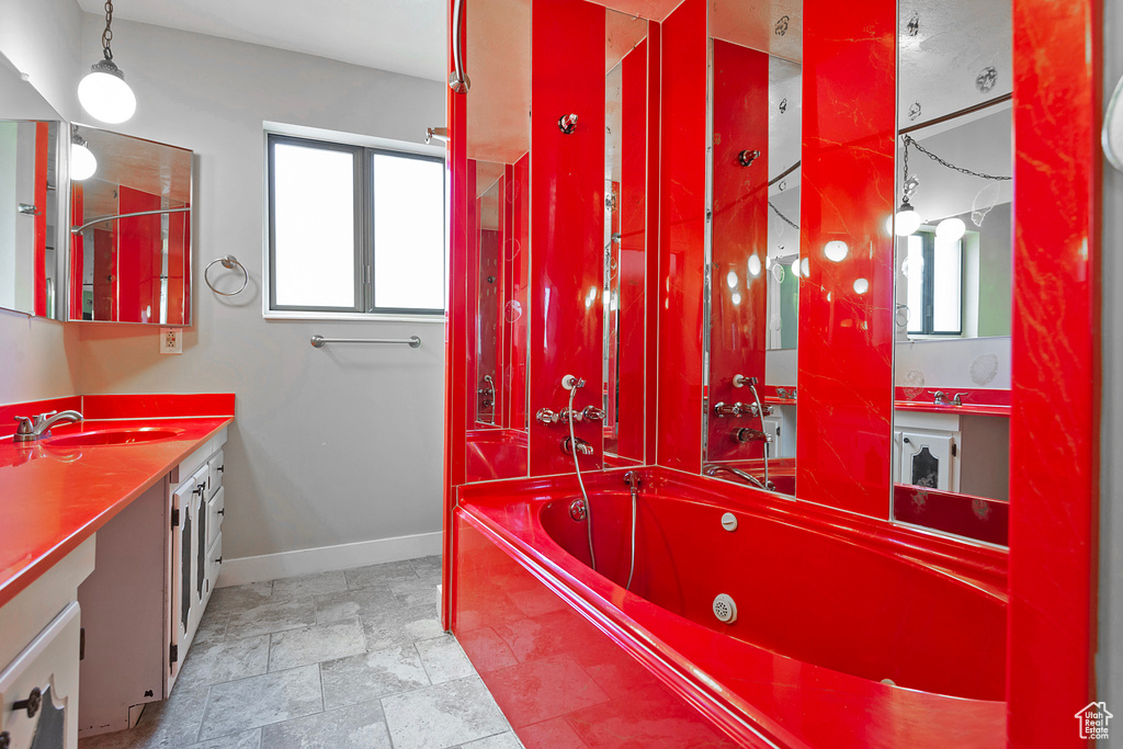 Full bathroom featuring a healthy amount of sunlight, baseboards, a bath, and vanity