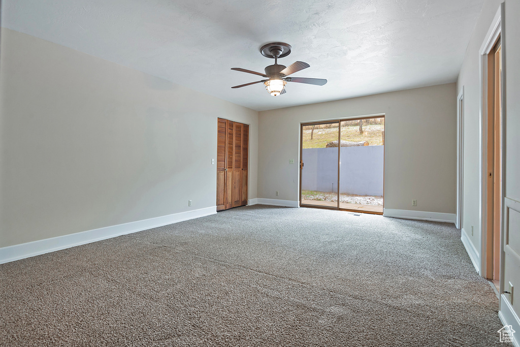 Empty room with carpet, baseboards, and ceiling fan