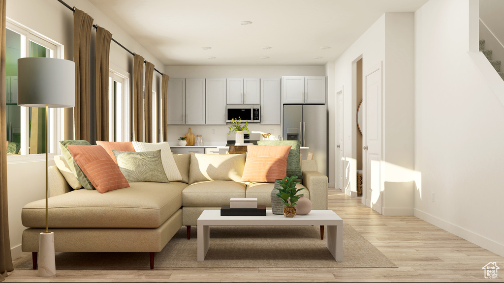 Living area featuring light wood-style floors, stairway, and baseboards