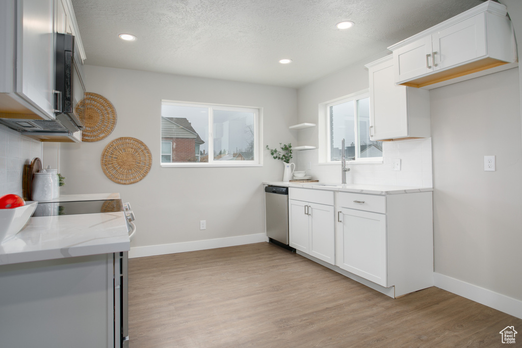 Kitchen with dishwasher, tasteful backsplash, light wood-style flooring, and baseboards