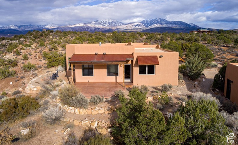 Exterior space featuring a patio area, a mountain view, and stucco siding