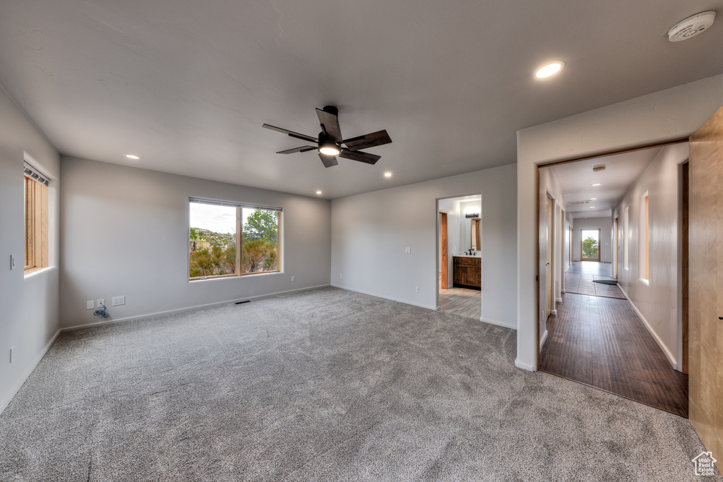 Carpeted empty room with visible vents, baseboards, a ceiling fan, and recessed lighting