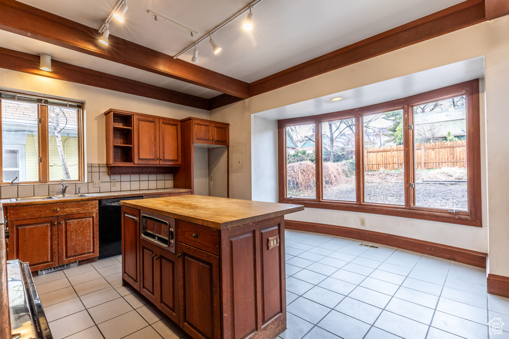 Kitchen with dishwasher, wooden counters, tasteful backsplash, and plenty of natural light