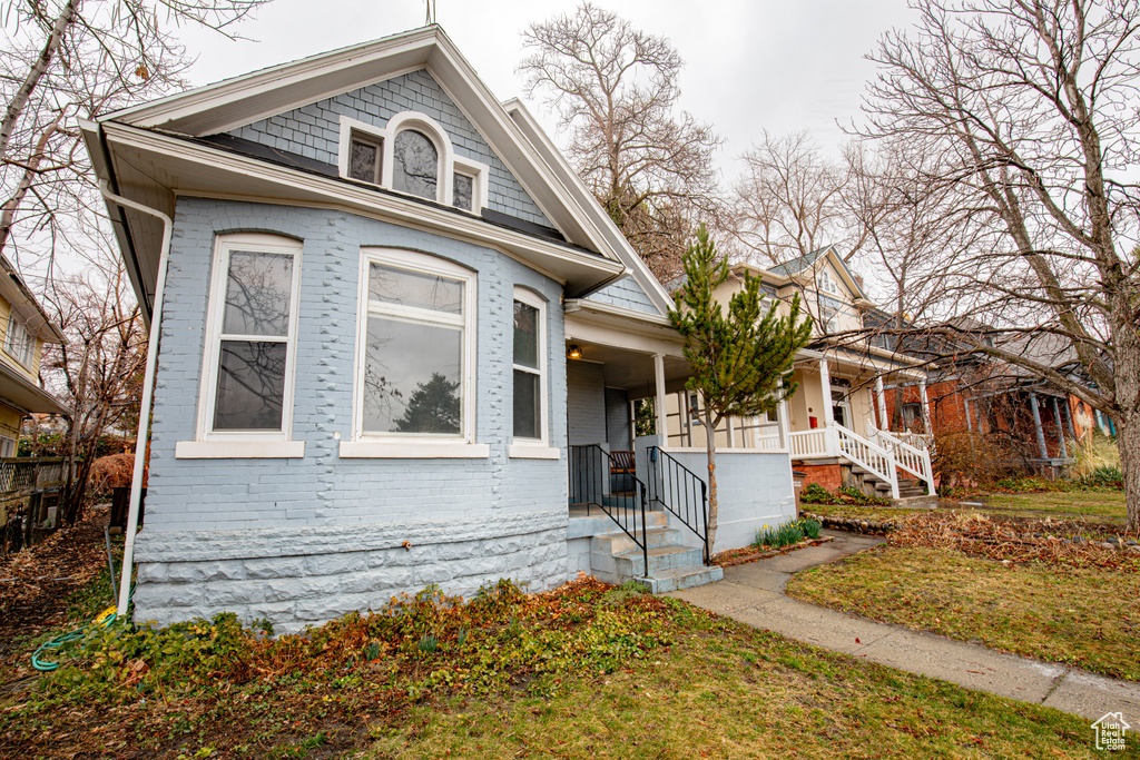 View of front facade featuring covered porch and brick siding