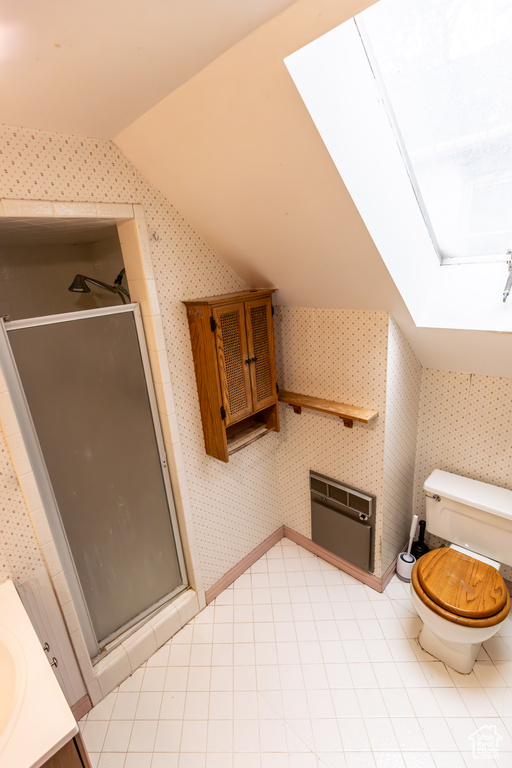 Bathroom featuring vaulted ceiling, a shower stall, toilet, and wallpapered walls