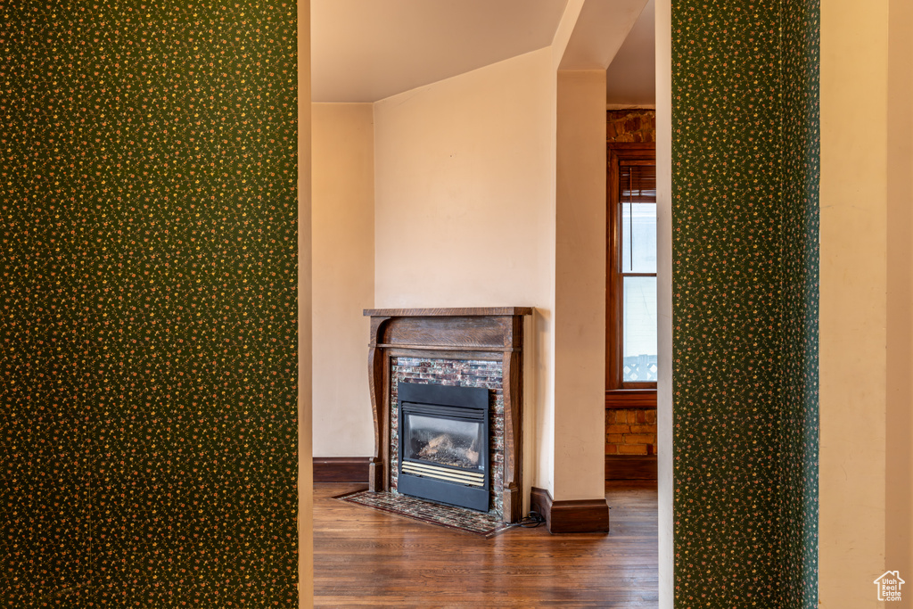 Unfurnished living room featuring a fireplace with flush hearth and wood finished floors