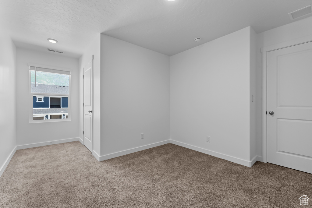 Unfurnished bedroom with baseboards, visible vents, and carpet flooring