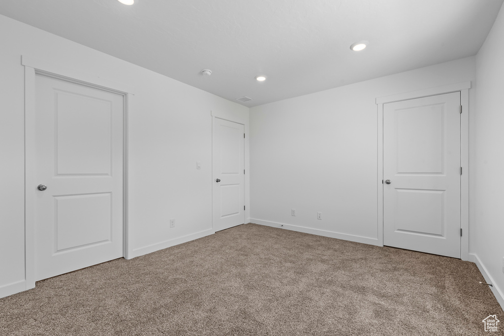 Carpeted empty room featuring baseboards and recessed lighting
