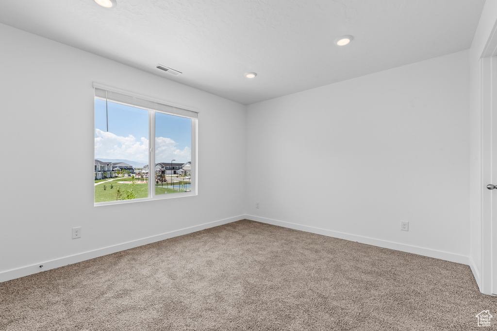 Unfurnished room with visible vents, baseboards, carpet flooring, and recessed lighting