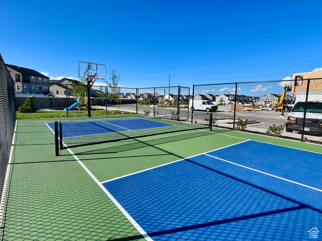 View of basketball court featuring community basketball court, fence, and a residential view