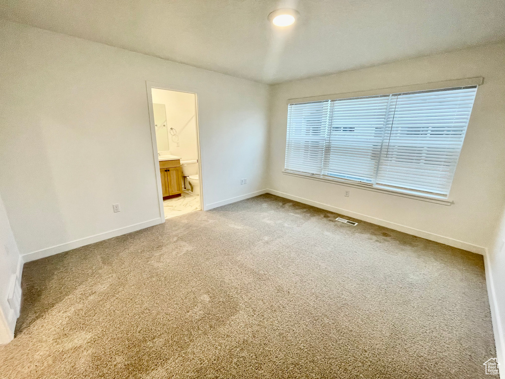 Unfurnished room with visible vents, light carpet, and baseboards